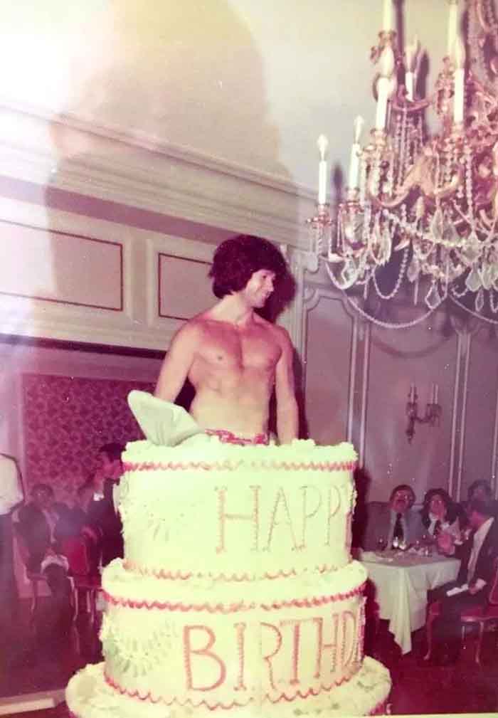 Christopher Riordan popping out of a cake
